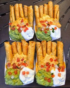 four trays filled with different types of food on top of each other, including tortilla shells and guacamole