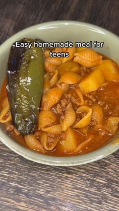 a bowl filled with pasta and a pickle on top of the bowl that says, easy homemade meal for teens