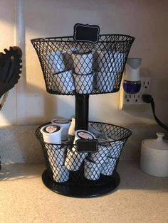 a black basket filled with toilet paper next to a sink