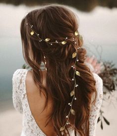 the back of a woman's head wearing a wedding dress with gold leaves on it