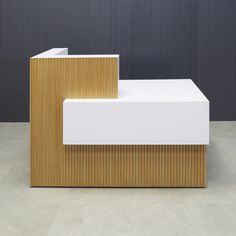 two white and wood benches sitting next to each other on a floor in front of a wall