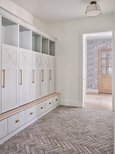Herringbone brick paver floor in the mudroom + light washed brick floors + white cubbies in the mudroom with drawers under a wood top bench + x detail on the cabinets + X overlay + brass appliance pulls on the mudroom storage | Aft Construction Mudroom Flooring, Herringbone Brick Floor, Stucco Homes