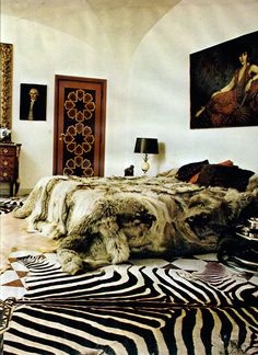 a bedroom with zebra print rugs and pictures on the wall above the bedspread
