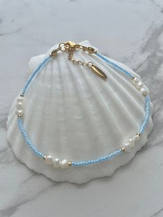 ❀ Oceana ❀ Anklet Our Oceana Anklet is made with the most beautiful Blue Ceylon coloured beads that glisten in the sunshine.   Please bear in mind that all Freshwater Pearls have unique shapes and sizes, no two pearls look the same. ♥ Dainty Freshwater pearl ♥ Blue Ceylon & gold coloured beads ♥ Stainless steel clasp, chain and brand tag ♥ Adjustable from 23,5cm to 26cm ↠ All my jewellery is handmade by me in the U.K  ➸Care Instructions ~ In order to keep your jewellery in perfect condition, we always advise keeping items out of contact with any chemicals, perfumes, lotions or water. Thank you for stopping by and please let me know if you have any questions or would like to personalise your jewellery :) Bijoux, Beaded Bracelets, Beaded Anklets, Beaded Ankle Bracelets, Anklet Jewelry, Handmade Anklets, Anklet Bracelet, Ankle Bracelets Diy, Beaded Bracelets Diy