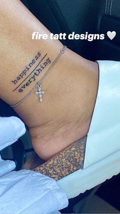 a woman's foot with a cross on it and the words happiness is everything