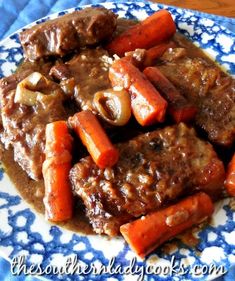 a blue and white plate topped with meat and carrots