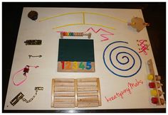 a table topped with lots of toys and magnets on top of white board covered in writing