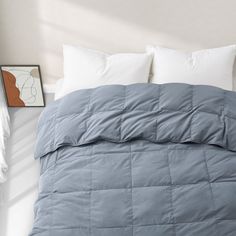 a bed with white pillows and blue comforter