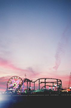 an amusement park with ferris wheel at dusk