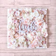 a white and pink flowered wall with the word love spelled in cursive letters