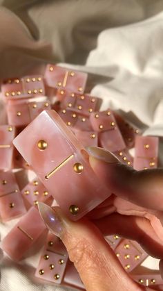 a person is playing with pink and gold dices