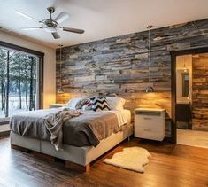 a bedroom with wood flooring and stone accent wall, along with sliding glass doors