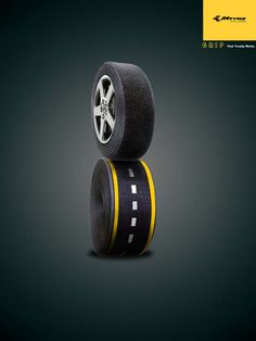two black and yellow tires stacked on top of each other in front of a dark background