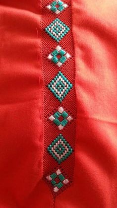 a red dress with green and white beading on it