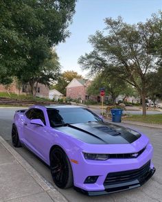 a purple camaro is parked on the street