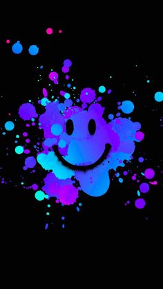 a smiley face painted in purple and blue on a black background with splots