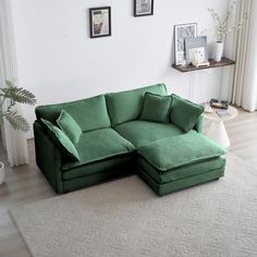 a living room with a large green couch and white rug on top of the floor