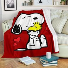 a snoopy dog blanket sitting on top of a couch