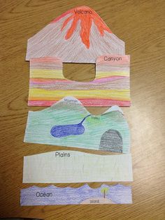 an image of a house made out of paper with volcanos and mountains on it