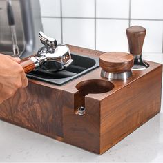a person is using a knife sharpener on a cutting board in front of a sink
