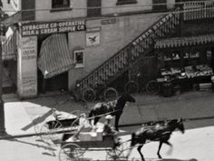 an old black and white photo of a horse pulling a carriage with people in it