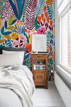 a bedroom with colorful wallpaper and white flooring