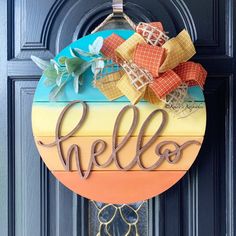 a colorful door hanger with the word hello painted on it and an orange bow