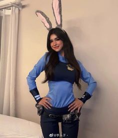 a woman in bunny ears is posing for the camera with her hands on her hips