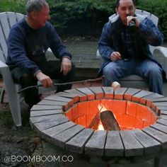a brick fire pit sitting on top of a grass covered field