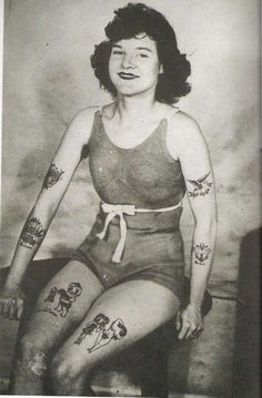 an old black and white photo of a woman with tattoos