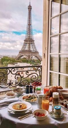 a table with food and drinks on it in front of the eiffel tower
