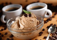 two cups of coffee with ice cream and coffee beans
