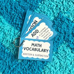 three blue tags with the words addition and subtraction are on a turquoise carpet