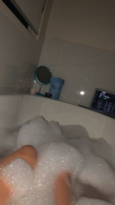 a bathtub filled with foam and bubbles next to a hair dryer