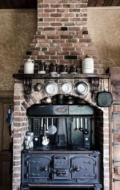 an old fashioned stove with many pots and pans on it's top shelf