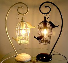 a lamp that is sitting on top of a table next to a birdcage
