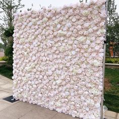 a large flower covered wall on the side of a road