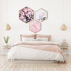 two framed posters on the wall above a bed in a room with hardwood flooring
