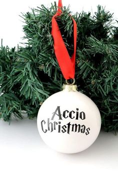an ornament hanging from a christmas tree with the words accio christmas on it