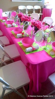 the table is set with bright pink and green plates, napkins, and flowers
