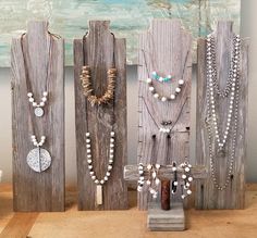 several necklaces are displayed on wooden boards