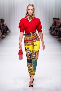 a model walks down the runway wearing colorful clothing