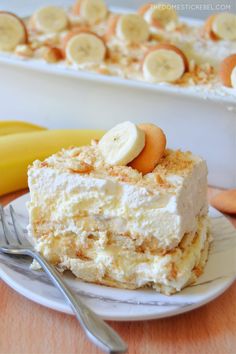 a piece of cake on a plate with bananas and other dessert items in the background
