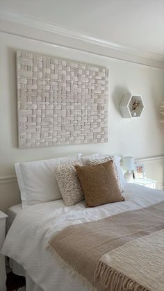 a white bed topped with pillows and blankets