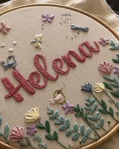 a close up of a embroidery with the word hello written in red and pink letters