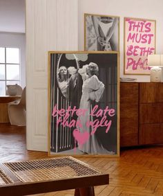 there are two posters on the wall in this living room, one is pink and the other is black and white