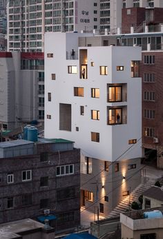 a tall white building with lots of windows on top of it's sides in the city