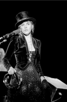 a woman wearing a top hat and holding a microphone