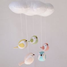 three little birds hanging from a cloud mobile