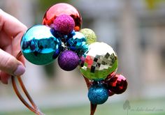 a person is holding some colorful ornaments on a stick in their hand and it looks like they have been made out of glass